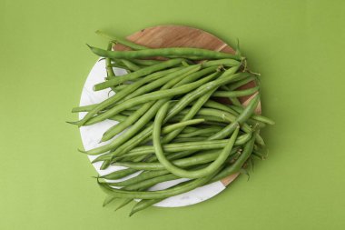 Fresh bean pods on green background, top view