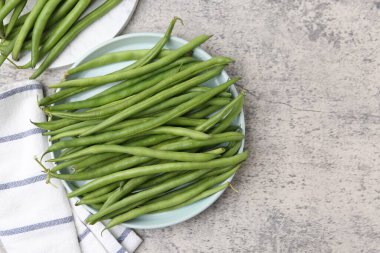 Gri desenli masada taze yeşil fasulye kabukları, üst manzara. Metin için boşluk