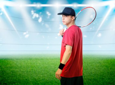 Stadyumda tenis oynayan raketli bir adam.