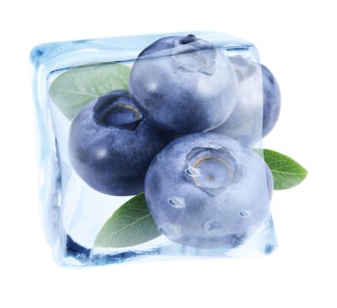 Beyaz arka planda olgun yaban mersini ve yeşil yapraklar buz küpünde