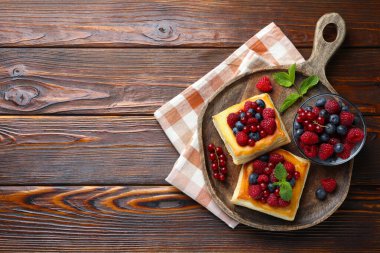 Böğürtlenli puf börekler ve ahşap masada nane şekeri, üst manzara. Metin için boşluk