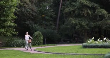 Parkta bisiklete binen mutlu kadın