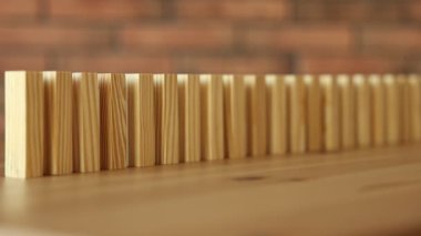 Risk. Tahta bloklar domino etkisi altında masaya düşüyor, yakın plan.