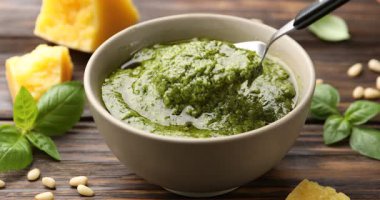 Ahşap masada kaşıkla sosu karıştıran kadın, yakın plan.