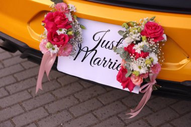 Düğün arabası. Cabriolet dekore edilmiş. Sadece evlilik kartı ve açık havada güzel çiçekler, yakın plan.