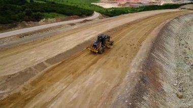 Yol yapımı. Ağır makine, eski kamyon ve tarak ile kum ocağı robot uçuş. 