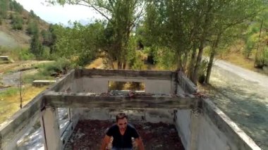 Harabe evindeki üzgün insan üzgün ve endişeli. Terk edilmiş Ev, fabrika kalıntıları, yıkılmış evler..