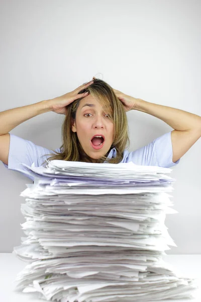 Business woman in shock at all the paper work