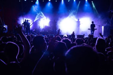 İnsanların önünde canlı konser aşamada kalabalık. Tezahürat hayranları