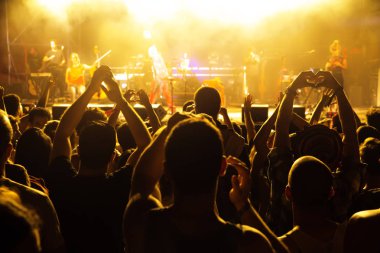 İnsanların önünde canlı konser aşamada kalabalık. Tezahürat ve ellerini yükselterek hayranları.