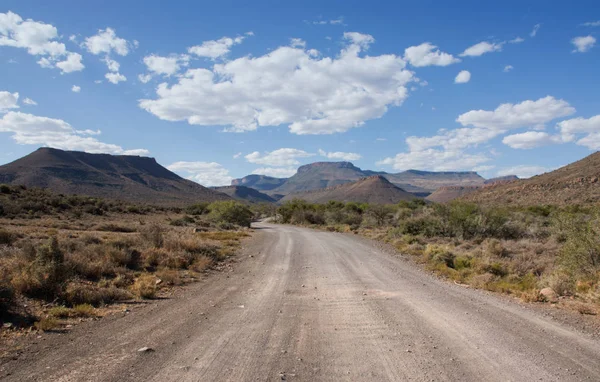 ground road in desert stretching to horizon on blue sky background, Southern African savanna