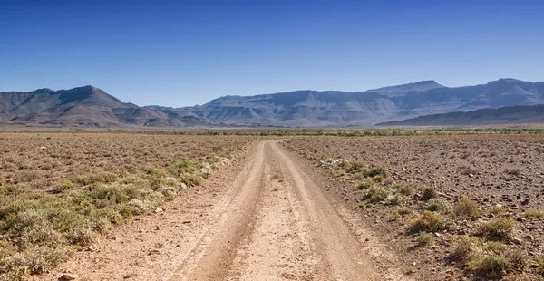 青い空を背景 南部アフリカのサバンナの地平線に砂漠をストレッチで地上道路 — ストック写真