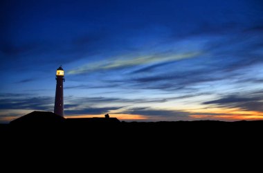 mellow Okyanusu günbatımı aydınlatılmış deniz feneri ile