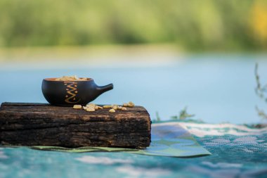 Çıtır, kızarmış ve tuzlu fıstık, soyulmuş. Doğal kahverengi ağaca doğal desenli bir arka plan üzerinde bir küçük kerimic tencerede besleyici snack. Temiz havada iştah açıcı yemek.