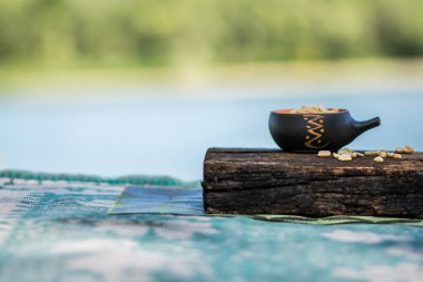 Çıtır, kızarmış ve tuzlu fıstık, soyulmuş. Doğal kahverengi ağaca doğal desenli bir arka plan üzerinde bir küçük kerimic tencerede besleyici snack. Temiz havada iştah açıcı yemek.