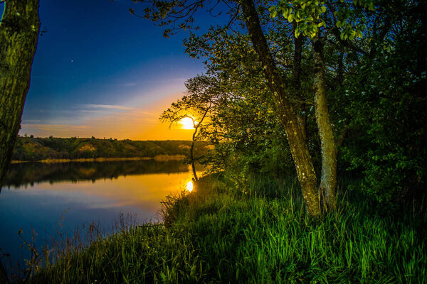Очень красивые и красочные ночные и вечерние пейзажи через реку Северский Донец в Ростовской области. Богатый лунный закат, как закат, горячий оттенок с яркими красками природы
