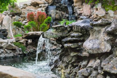 Su yaşayan ve yosun büyüyen çok güzel yapay şelaleler. Su yukarıdan akar, su sıçramalarına ve çevresinde düşer. Açık alanlarda ve parkları yürüyüş için. Yaz dönemi, gölet serin.