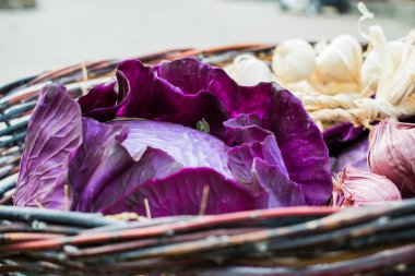 Parlak ve sulu, Olgun mor lahana. Grapevine yapılan bir hasır sepet içinde ev hasat. Pembe ve sakin salata yaprakları