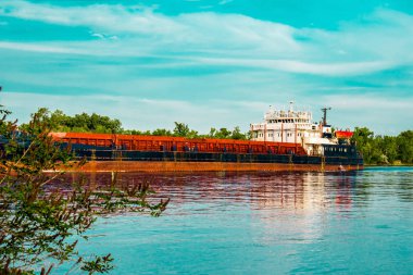 Bir gemi, bir mavna, bir yat, Rostov bölgesi Nehri üzerinde bir tekne. Su ulaştırma araçları yeşil yapraklı peyzaj ve mavi gökyüzü bulutlu arka planı suya yansıyan