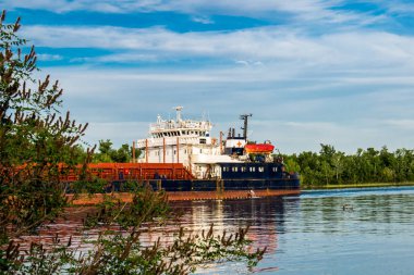 Bir gemi, bir mavna, bir yat, Rostov bölgesi Nehri üzerinde bir tekne. Su ulaştırma araçları yeşil yapraklı peyzaj ve mavi gökyüzü bulutlu arka planı suya yansıyan