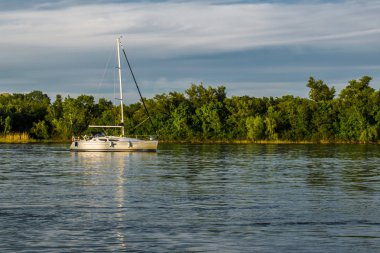 Bir gemi, bir mavna, bir yat, Rostov bölgesi Nehri üzerinde bir tekne. Su ulaştırma araçları yeşil yapraklı peyzaj ve mavi gökyüzü bulutlu arka planı suya yansıyan