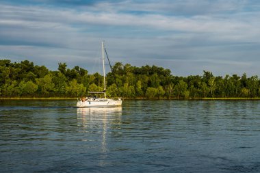 Bir gemi, bir mavna, bir yat, Rostov bölgesi Nehri üzerinde bir tekne. Su ulaştırma araçları yeşil yapraklı peyzaj ve mavi gökyüzü bulutlu arka planı suya yansıyan
