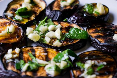 Taze sarımsak ve yeşillik bir tabakta yuvarlak beyaz, sıcak ve iştah açıcı ile mavi kızarmış patlıcan. Ev yapımı yemek. Lezzetli ızgara gıda