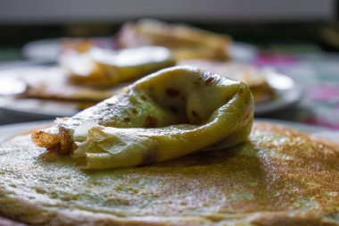 İştah açıcı altın krep gevrek kabuk, evde pişmiş ile. Yağlı ve sıcak krep yerken üzerine süt
