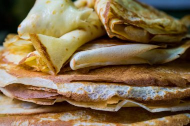 İştah açıcı altın krep gevrek kabuk, evde pişmiş ile. Yağlı ve sıcak krep yerken üzerine süt