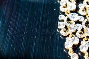 Kulağa altın, sarı küpe. Büyük ve küçük beyaz taşlarla akşam ve zarif süslemeleri. Altın takı ve Bijuteri