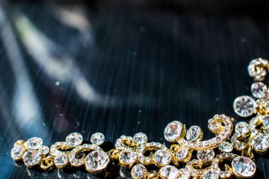 Kulağa altın, sarı küpe. Büyük ve küçük beyaz taşlarla akşam ve zarif süslemeleri. Altın takı ve Bijuteri