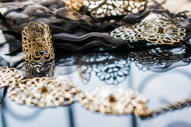 Altın takı sarı ve farklı tonları var. Yansıtıcı yüzeyi ajur desenleriyle metal alaşım takı. Şık ve moda tasarım.