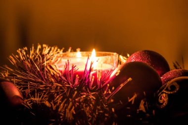 Noel tinsel ve yılbaşı süsleri ve süslemeler balmumu mum ışığında. Işık, büyülü ve rahat hissediyorum tatil sıcak. Eve Noel.