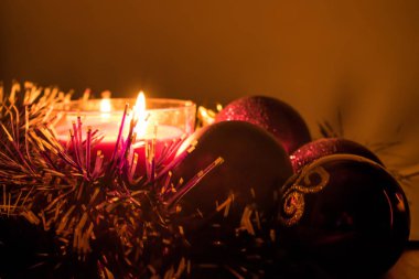 Noel tinsel ve yılbaşı süsleri ve süslemeler balmumu mum ışığında. Işık, büyülü ve rahat hissediyorum tatil sıcak. Eve Noel.
