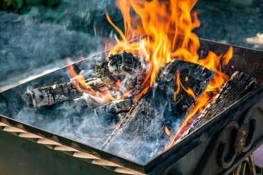 Metal ızgara, sahte, el yapımı, bir desen ile. Dumanlı Barbekü ve ızgara ürünleri için ahşap sıcak bir ateşe verdim. Güneşli bir günde dışarıda.