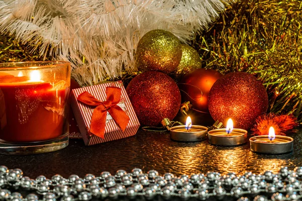 Noel ve yeni yıl kompozisyon Noel ağaçları ve metin için yer ile karanlık bir arka plan üzerinde mum ışığında altın tinsel kırmızı top. Tatil hediye, sürpriz. Kış koniler ve süsler güzel ışıklar.