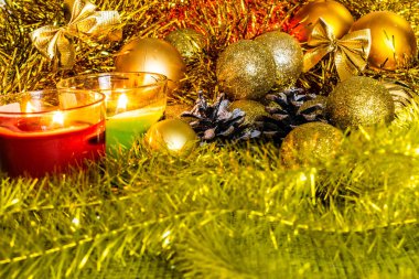 Noel süslemeleri ve oyuncaklar ile arka plan. Noel tinsel, kış koniler ve Gümüş boncuk. Zengin renk altın ve limon. Altın top ve mum ışığında şenlikli bir kompozisyon içinde parlak parıltı