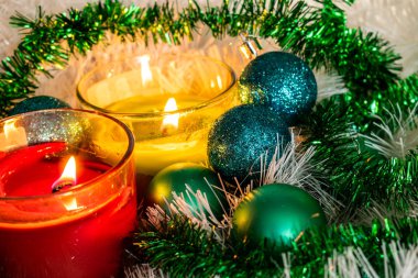 Yeni yıl, yeşil toplar ve süslemeleri Noel ağacı için. Beyaz tinsel ve boncuk bir limon zemin üzerine parlak ve güzel sahne. Noel Kış kompozisyon mum ışığında.