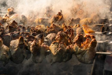 Izgara et, şiş ve ahşap saplı altın domuz eti. Doğada güzel kokulu et yemekleri pişirme sürecinde çok fazla duman var. Yaz mutfağı. Çiğ et yanıyor..