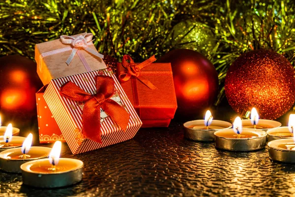 Noel ve yeni yıl kompozisyon Noel ağaçları ve metin için yer ile karanlık bir arka plan üzerinde mum ışığında altın tinsel kırmızı top. Tatil hediye, sürpriz. Kış koniler ve süsler güzel ışıklar.