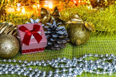Hediyeler arasında Noel tinsel ve parlak oyuncaklar ve süslemeleri ile renkli küçük hediye kutuları. Kış ve tatil sahne mum ışığında.