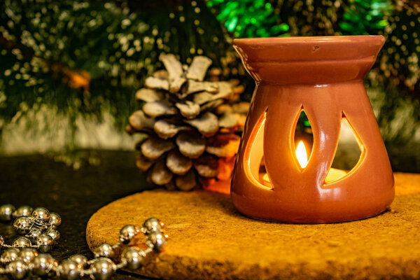 Праздничная рождественская композиция с восковыми свечами, подарочными коробками и серебряными бусами. Декорации к новогоднему празднику. На темном фоне в теплых световых декораций, конусы, стенд и огни среди зеленой сосны с местом для надписей и пустое пространство для
 