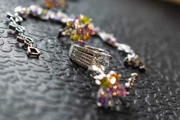 银色首饰与彩色的石头 不同颜色的立方氧化锆 精致的色调 珠宝粉红色 黄色和淡紫色 金属制品上的莱茵石 女性的时尚形象 — 图库照片
