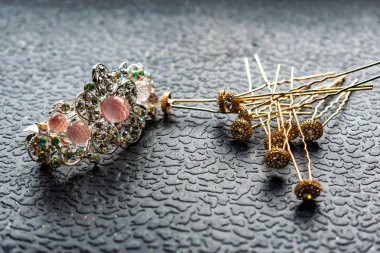 Güzel otomatik barrette parlak taşlar ve karanlık dokulu arka plan üzerinde pembe boncuk. Beyaz rhinestones ile altın tokalar. Kadınlar için takı ve aksesuar seti.