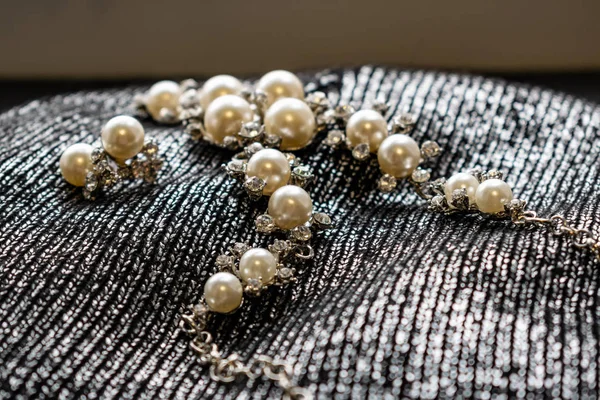 女性の金属製のジュエリーは真珠から成っています シルバー アクセサリー 銀の布背景 テクスチャ上の女の子 透明な石とラインス トーン パール乳製品 — ストック写真