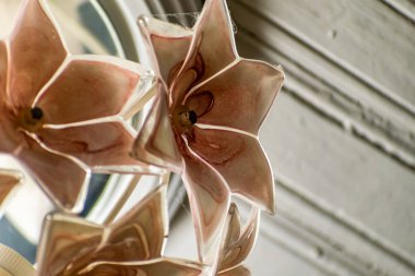 Cam pembe avize ışık boya ve örümcek ağları ile kirli beyaz ve eski ahşap tavan dokusunun arka planda bir çiçek buketşeklinde. Ev aydınlatma basit ucuz oda