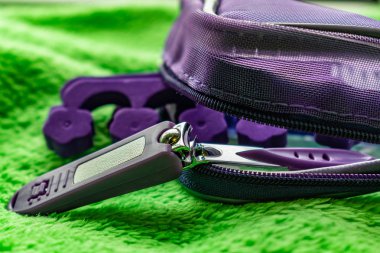 Pedikür ayak tırnakları için kadın kozmetik seti. Özel taşıma maşa, pliers, köpük fırça yüz fırçası. Mor kilit yeşil peluş arka plan kozmetik çantası seti