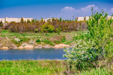 Erken bahar manzara, Shakhty kentinde Rostov bölgesinde, Grushevka Nehri üzerinde. Sarı ve turuncu sıcak ışıkta güneşli günbatımı. Yerel kıyı üzerinde Kuru Çim ve TH güzel bir yansıma
