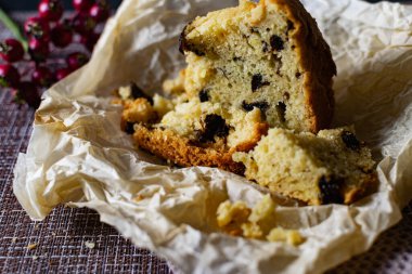 İçinde kuru erik olan büyük bir dilim ev yapımı turta. Portakal ve Elma, kağıt üzerinde kesilmiş. Lezzetli kek kırıntılarının yanında böğürtlen ve meyveli kek gibi gözenekli hamur işi.