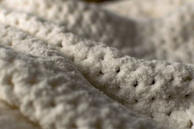 Beyaz ve gri renkte ince ve dokulu kumaş. Kabartmalı tekstil deseni, hoş ve narin, kadife gibi ve desenli tasarım ve dekorasyon için arka plan..